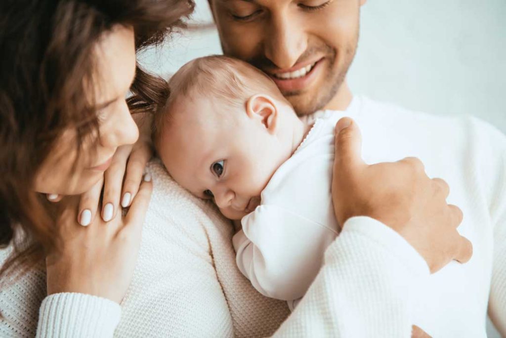 Cropped View Of Happy Man Holding Adorable Baby Near Smiling Wif